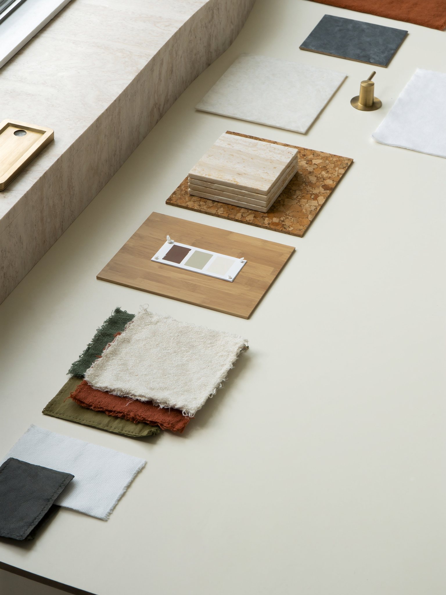 Interior design material board with stone, oak, linen and brass samples